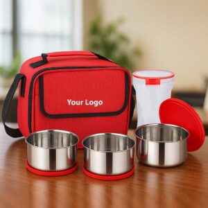 red lunchbox 3 steel containers 1 plastic tumbler displayed on office table