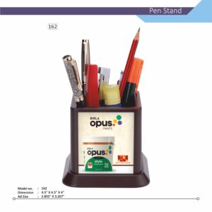 A high-angle image of a dark brown square Customizable Pen Stand, model no. 162, filled with pens, a pencil, a thimble, a stapler, and paper notes